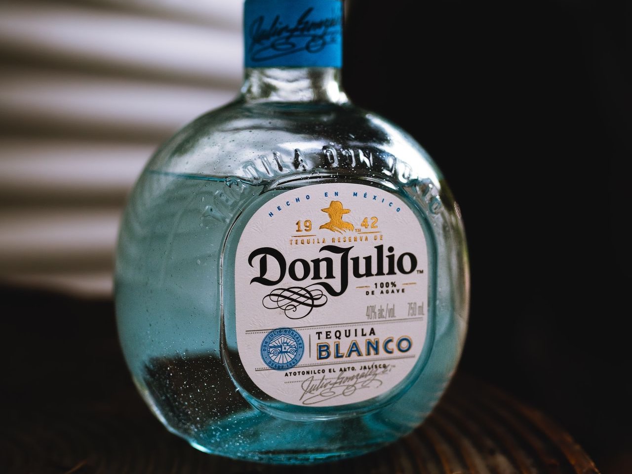 a bottle of tequila sitting on top of a wooden table