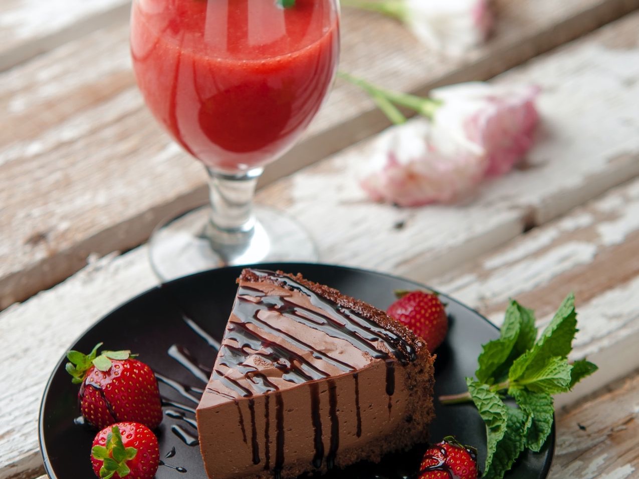 chocolate cake beside strawberries and wine glass