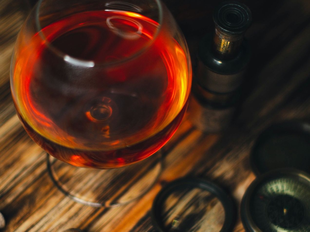 a glass of wine sitting on top of a wooden table