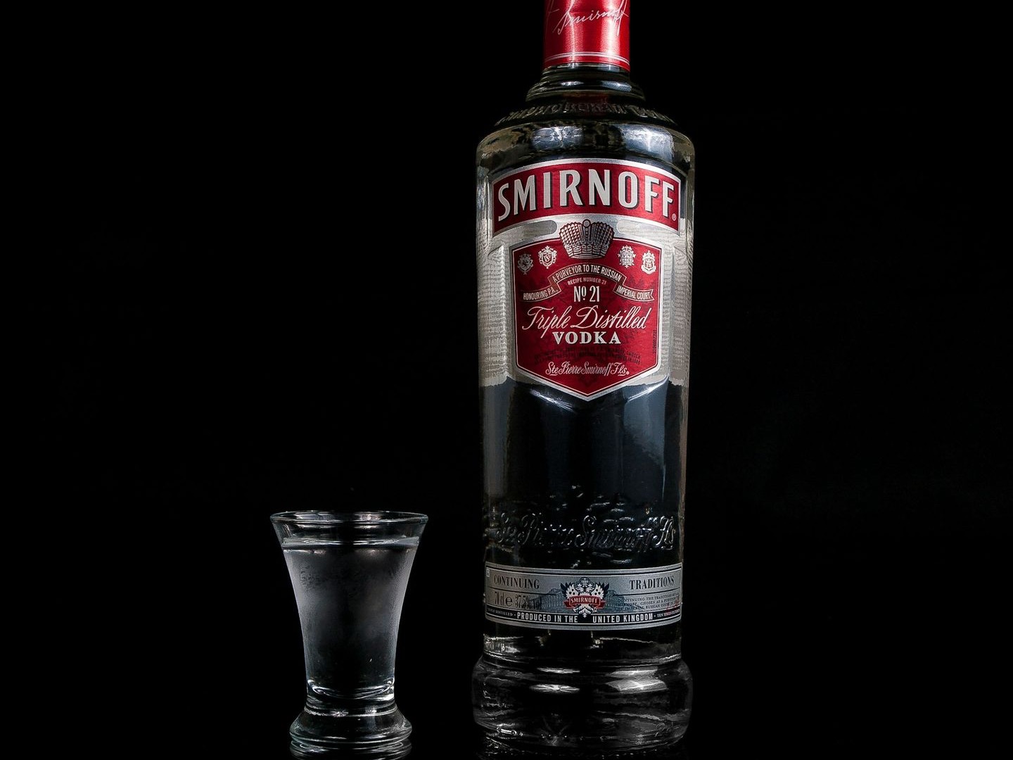 Smirnoff vodka bottle besides shot glass